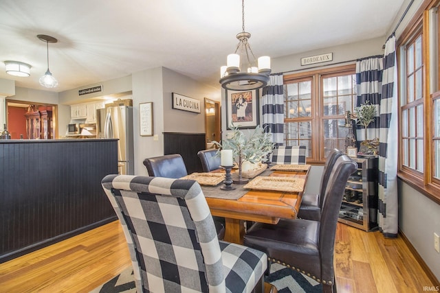 dining space with a notable chandelier and light wood-type flooring