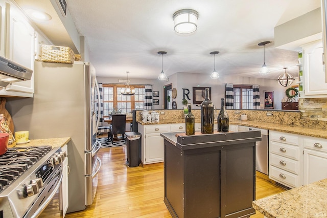 kitchen with white cabinetry, a center island, and decorative light fixtures