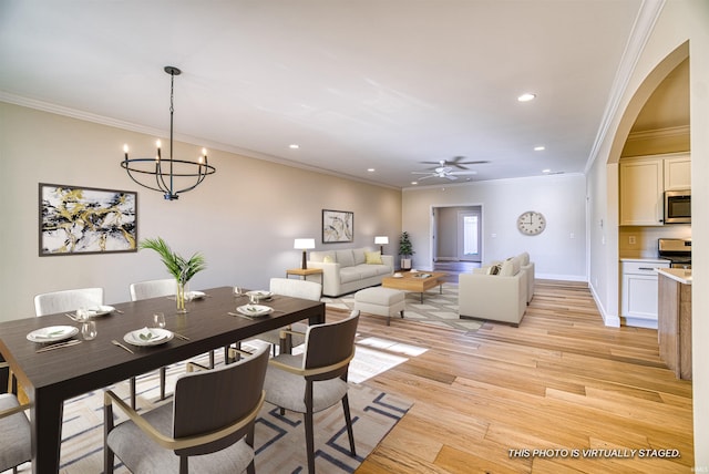 dining area featuring crown molding, ceiling fan with notable chandelier, and light hardwood / wood-style floors