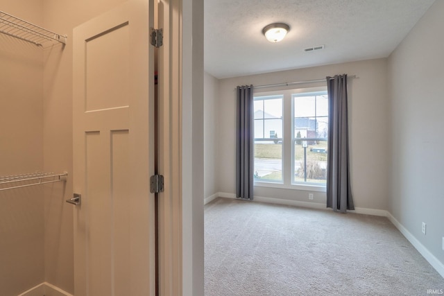 interior space with a textured ceiling and carpet flooring