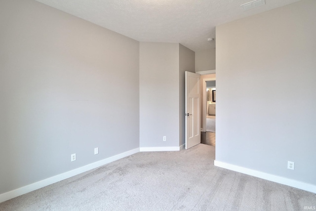 carpeted spare room featuring a textured ceiling