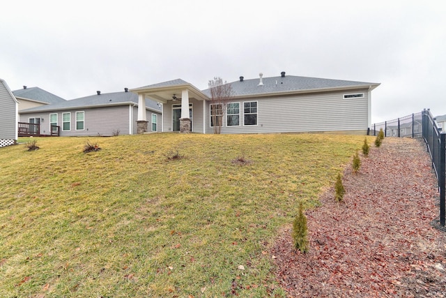 rear view of house featuring a yard and ceiling fan