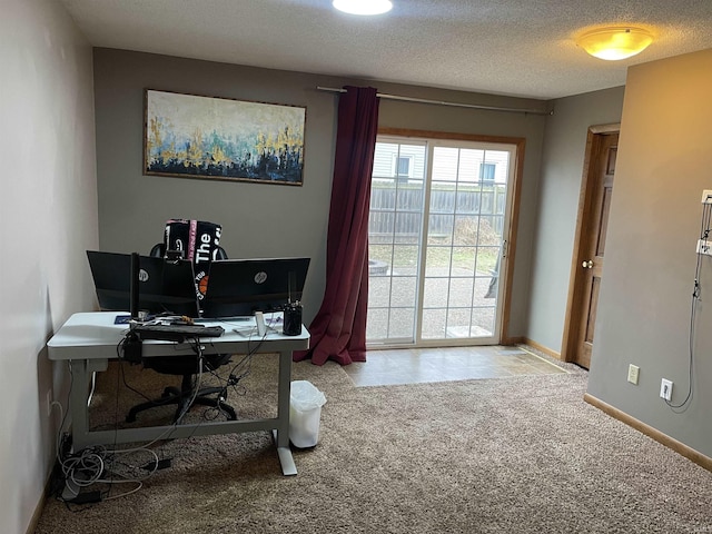 office area featuring light carpet and a textured ceiling