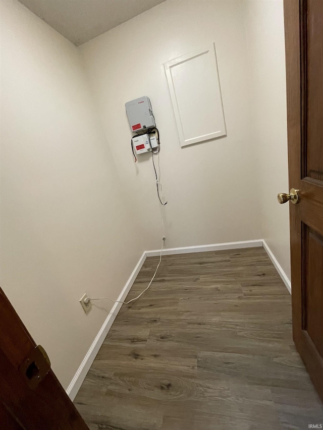 clothes washing area with dark hardwood / wood-style flooring