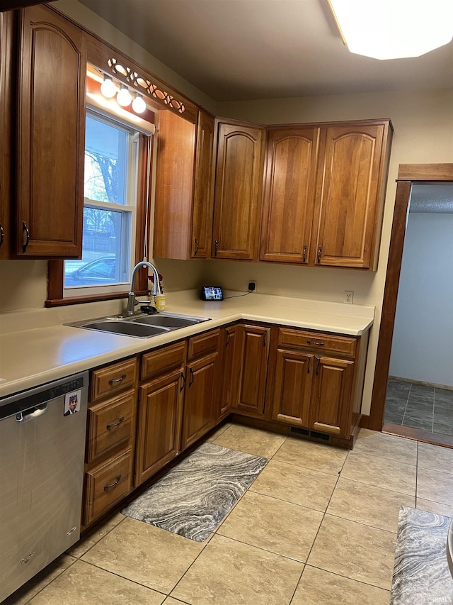 kitchen with light tile patterned flooring, dishwasher, and sink