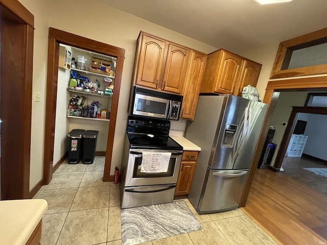 kitchen featuring stainless steel appliances and light tile patterned flooring