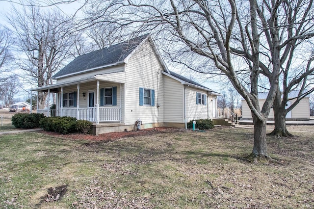 view of side of home with a yard and covered porch