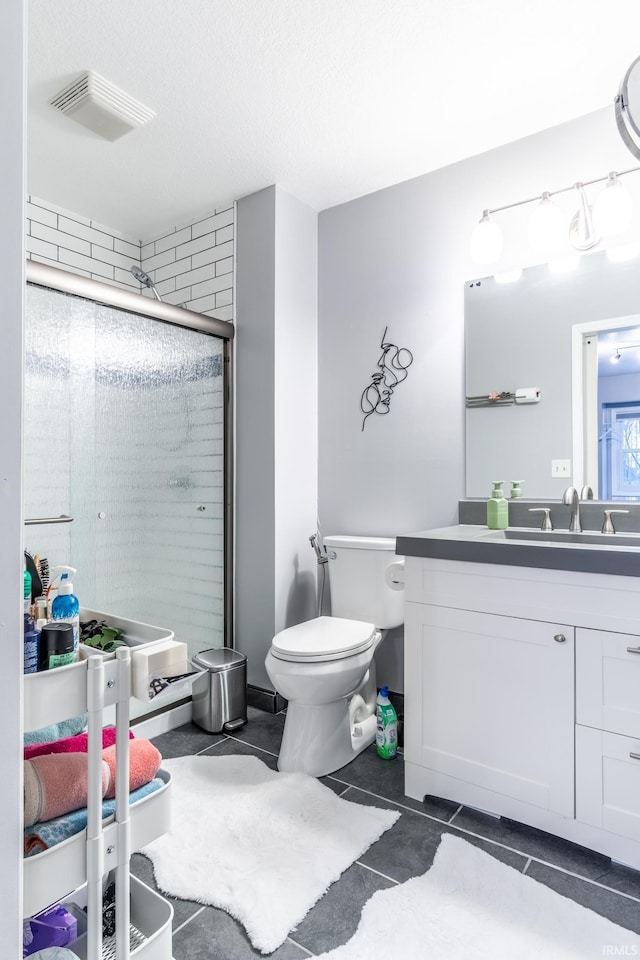 bathroom with vanity, a textured ceiling, toilet, and walk in shower