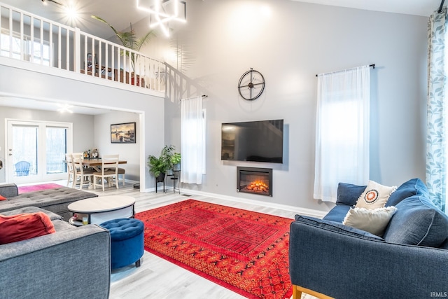 living room featuring a towering ceiling and hardwood / wood-style floors