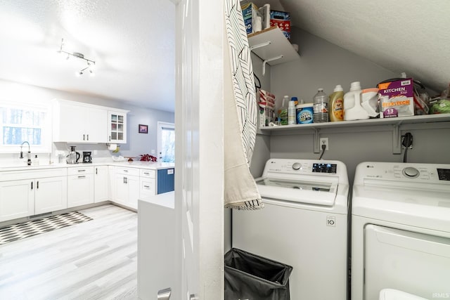 washroom featuring sink, independent washer and dryer, and a textured ceiling