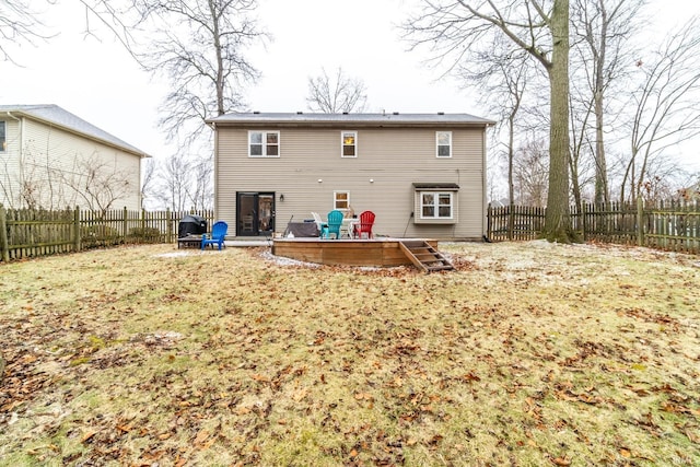 rear view of house featuring a lawn and a deck