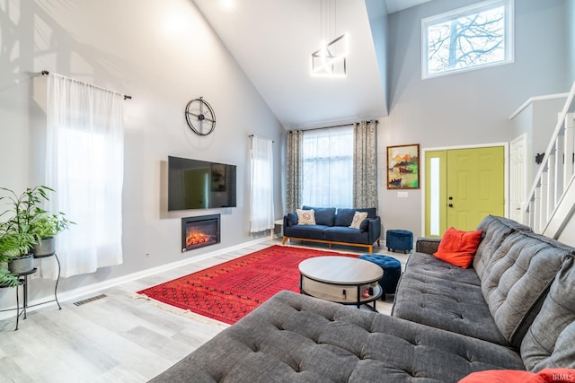 living room featuring a high ceiling and hardwood / wood-style floors