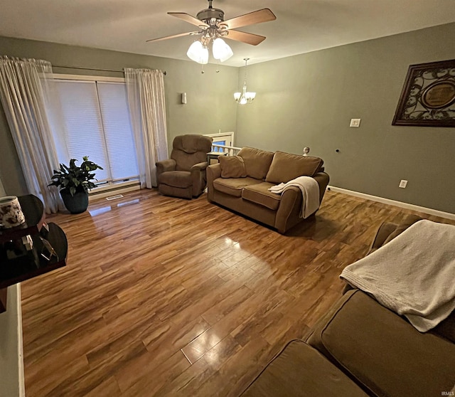 living room with hardwood / wood-style flooring and ceiling fan with notable chandelier