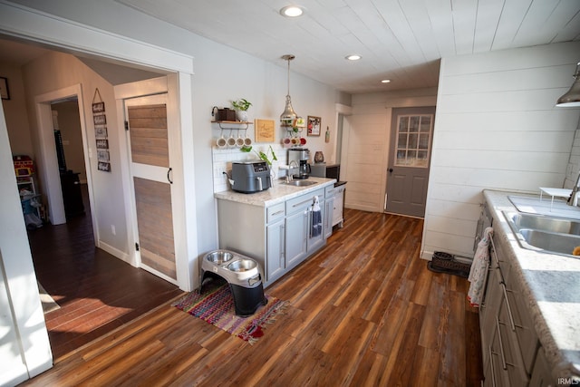 kitchen featuring dark wood-type flooring, sink, and decorative light fixtures