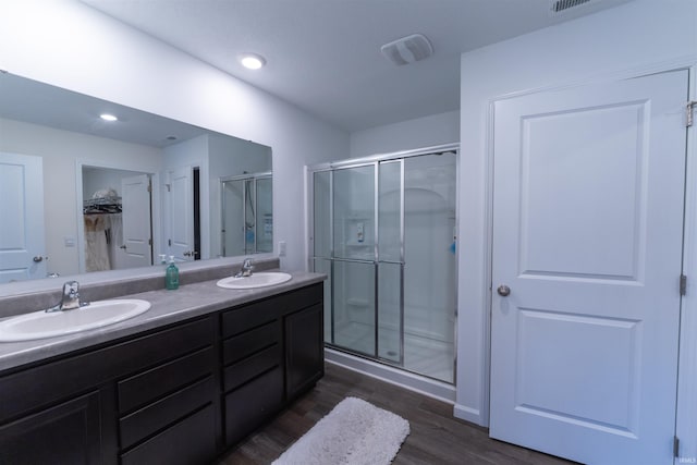 bathroom with walk in shower, vanity, and hardwood / wood-style floors