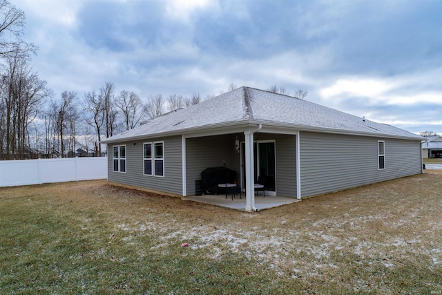 back of property with a lawn and a patio area