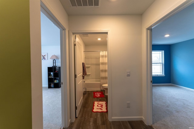 hallway with dark colored carpet