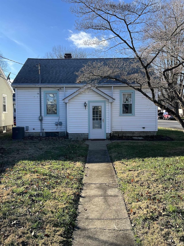 view of front of home with central AC and a front yard