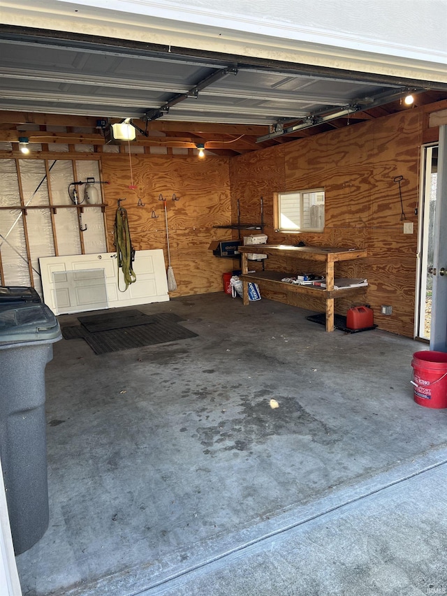 garage featuring a garage door opener and wood walls