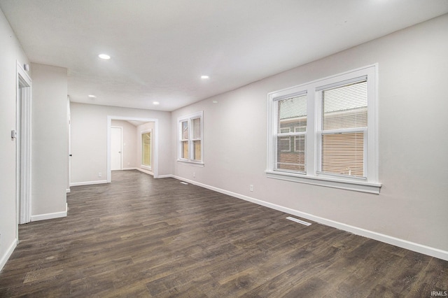 unfurnished room with dark wood-type flooring