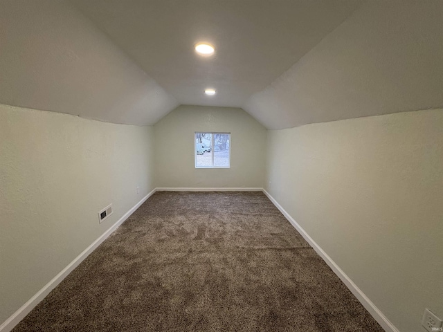 additional living space with vaulted ceiling and carpet flooring