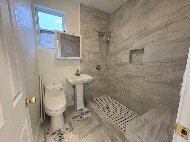 bathroom featuring toilet and tiled shower