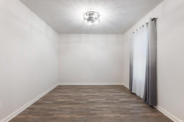 unfurnished room featuring dark hardwood / wood-style flooring and a textured ceiling