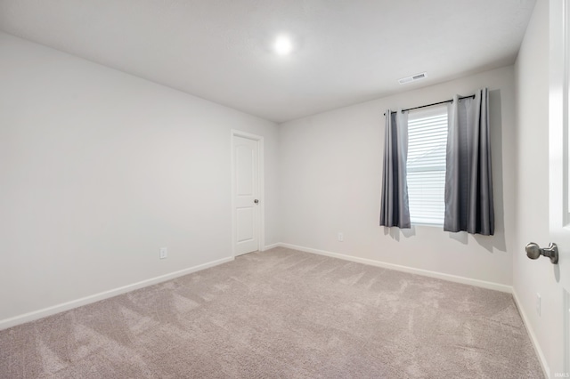 spare room featuring light colored carpet