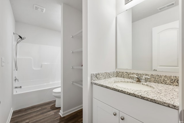 full bathroom with wood-type flooring, vanity, washtub / shower combination, and toilet