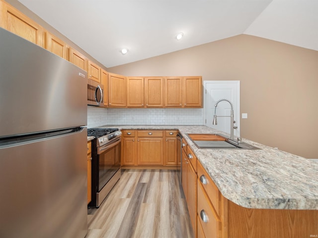 kitchen with stainless steel appliances, vaulted ceiling, sink, and light brown cabinetry