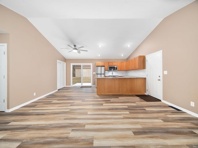 kitchen featuring kitchen peninsula, high vaulted ceiling, ceiling fan, light hardwood / wood-style floors, and stainless steel appliances