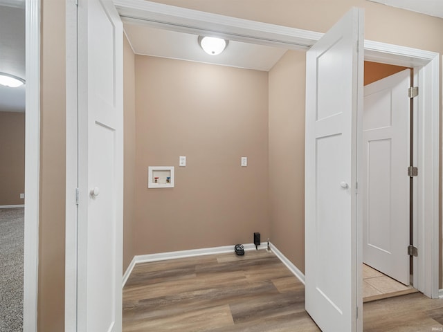 clothes washing area featuring washer hookup and light hardwood / wood-style flooring