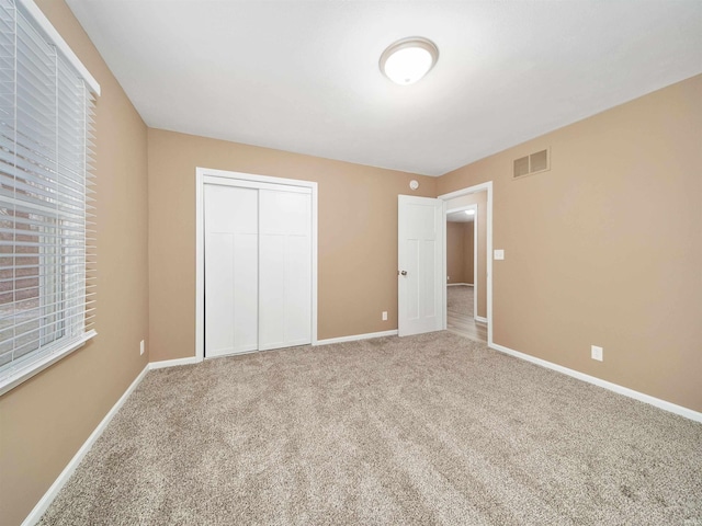 unfurnished bedroom with carpet floors and a closet