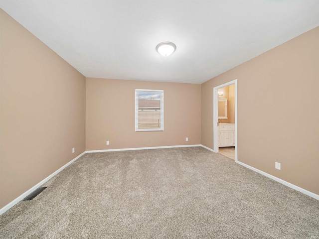 unfurnished room featuring light carpet