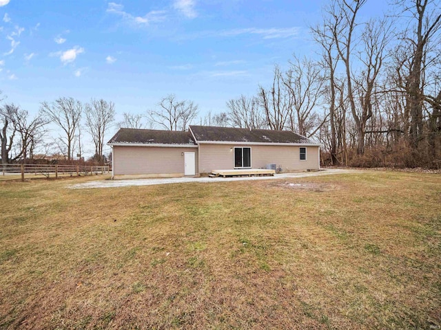 back of property with a wooden deck and a yard