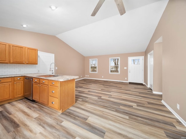 kitchen featuring lofted ceiling, sink, tasteful backsplash, and kitchen peninsula