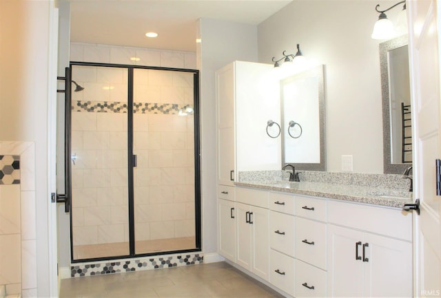 bathroom featuring vanity, tile patterned flooring, and a shower with door