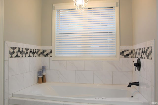 bathroom featuring plenty of natural light and tiled bath