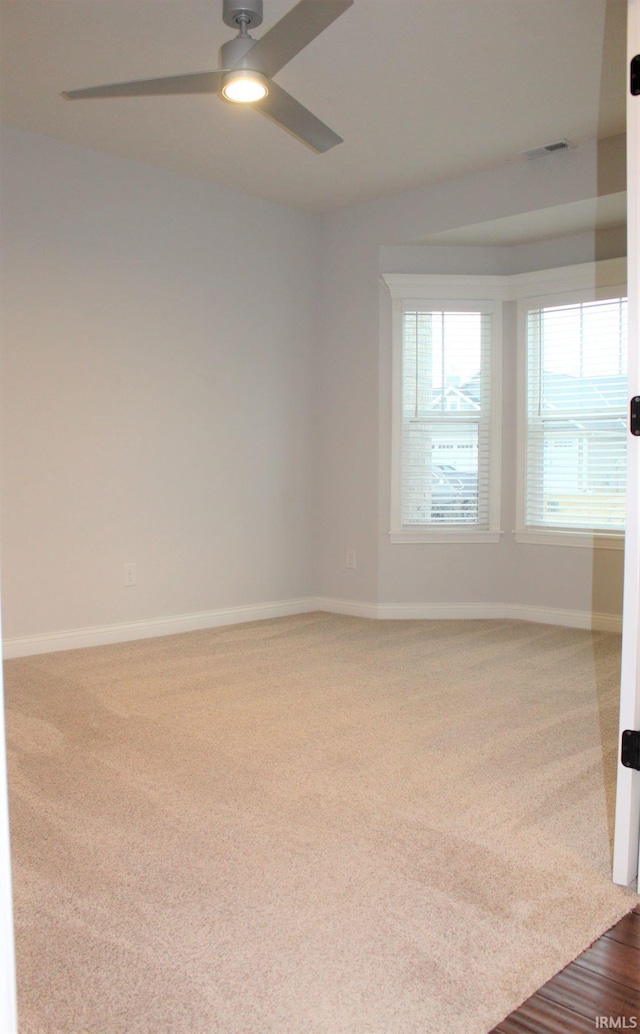 spare room featuring carpet floors and ceiling fan