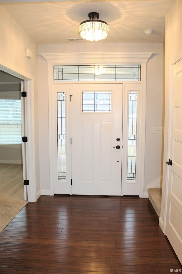 foyer with a healthy amount of sunlight and dark wood-type flooring