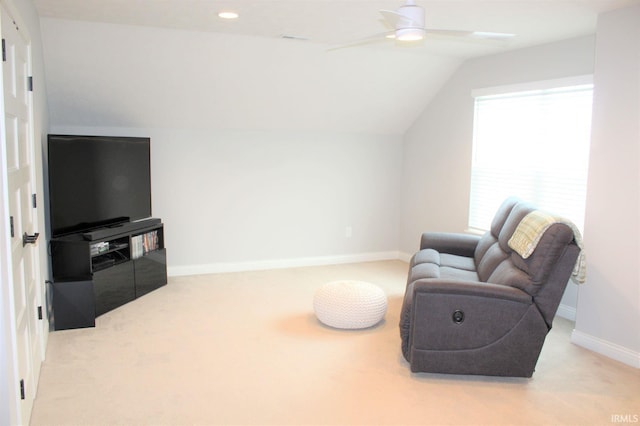 living area featuring lofted ceiling, light colored carpet, and ceiling fan