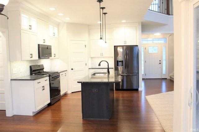 kitchen featuring sink, white cabinetry, decorative light fixtures, a center island with sink, and stainless steel appliances