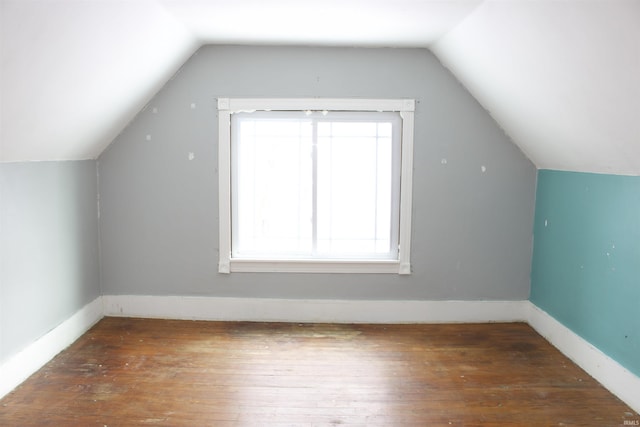 additional living space featuring dark wood-style floors, baseboards, and vaulted ceiling