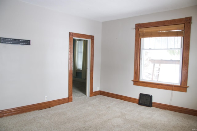 unfurnished room featuring baseboards and light colored carpet