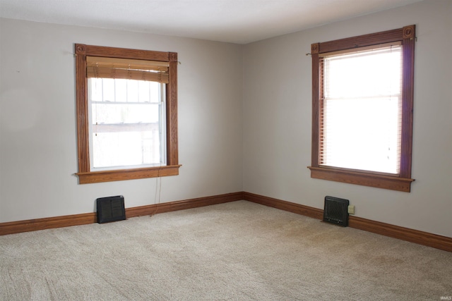 unfurnished room with a wealth of natural light, carpet, and baseboards