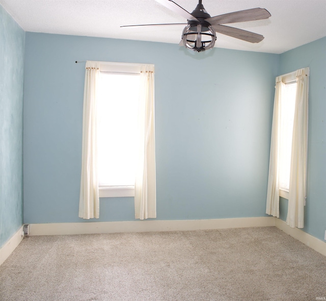 empty room featuring carpet flooring and a ceiling fan