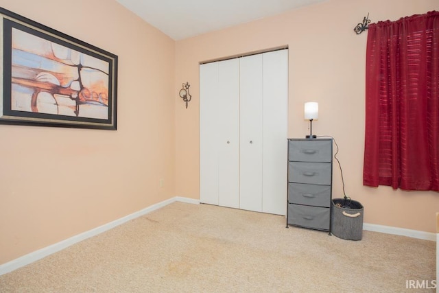 unfurnished bedroom with carpet, a closet, and baseboards