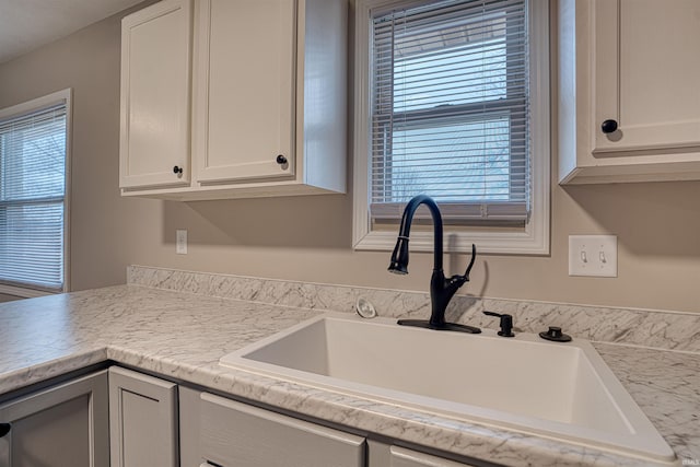 kitchen featuring a sink and white cabinetry