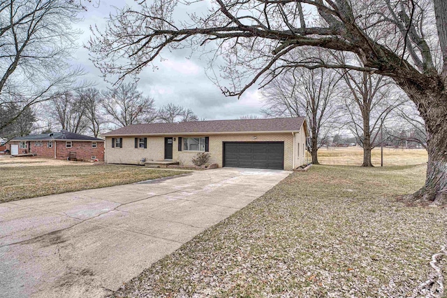 ranch-style house featuring a garage, a front yard, concrete driveway, and brick siding