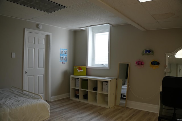 bedroom featuring light hardwood / wood-style flooring and a paneled ceiling